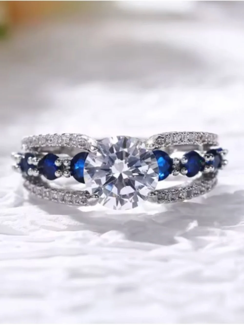 Silver Ring with Deep Blue Stones and Clear Center Gem.